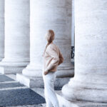 The pillars of health. A woman looking at big classical concrete pillars